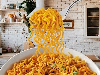 Forkful of seasoned Maggi noodles lifted from a white bowl.