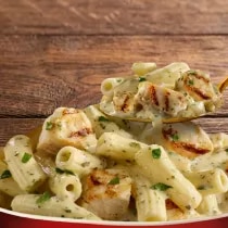 A Macaroni Cheese with grilled chicken.