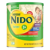 A canister of Nido 2+ with a green label and lid above a young girl smiling and pointing.