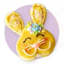 A cookie decorated like an Easter bunny on a purple circle.