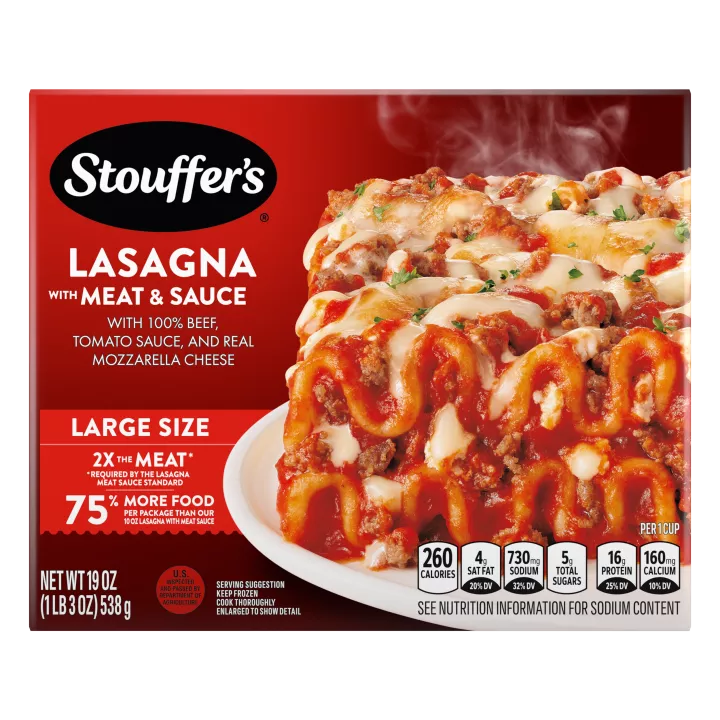 A plate of Lasagna with Meat & Sauce on a table below the product name, Large Size label, and "2x the Meat" label.