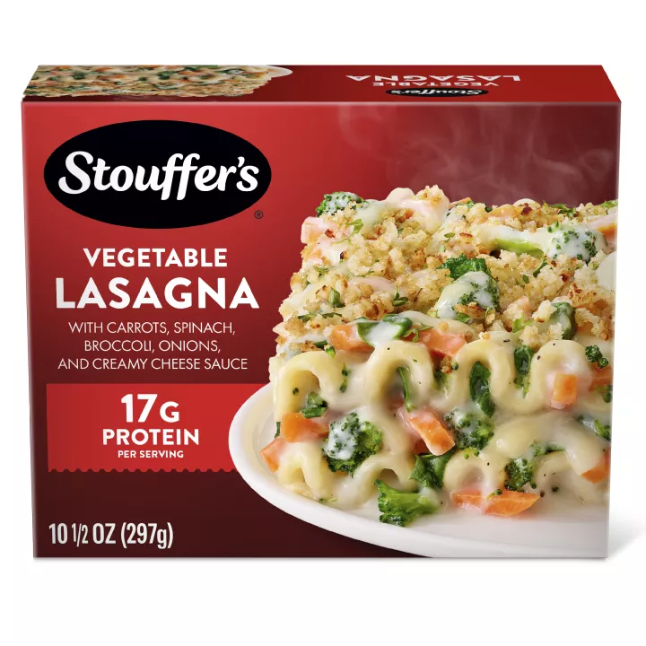 Box of Veggie Lovers Lasagna with a plate of lasagna on a table under the product name and STOUFFER'S logo.
